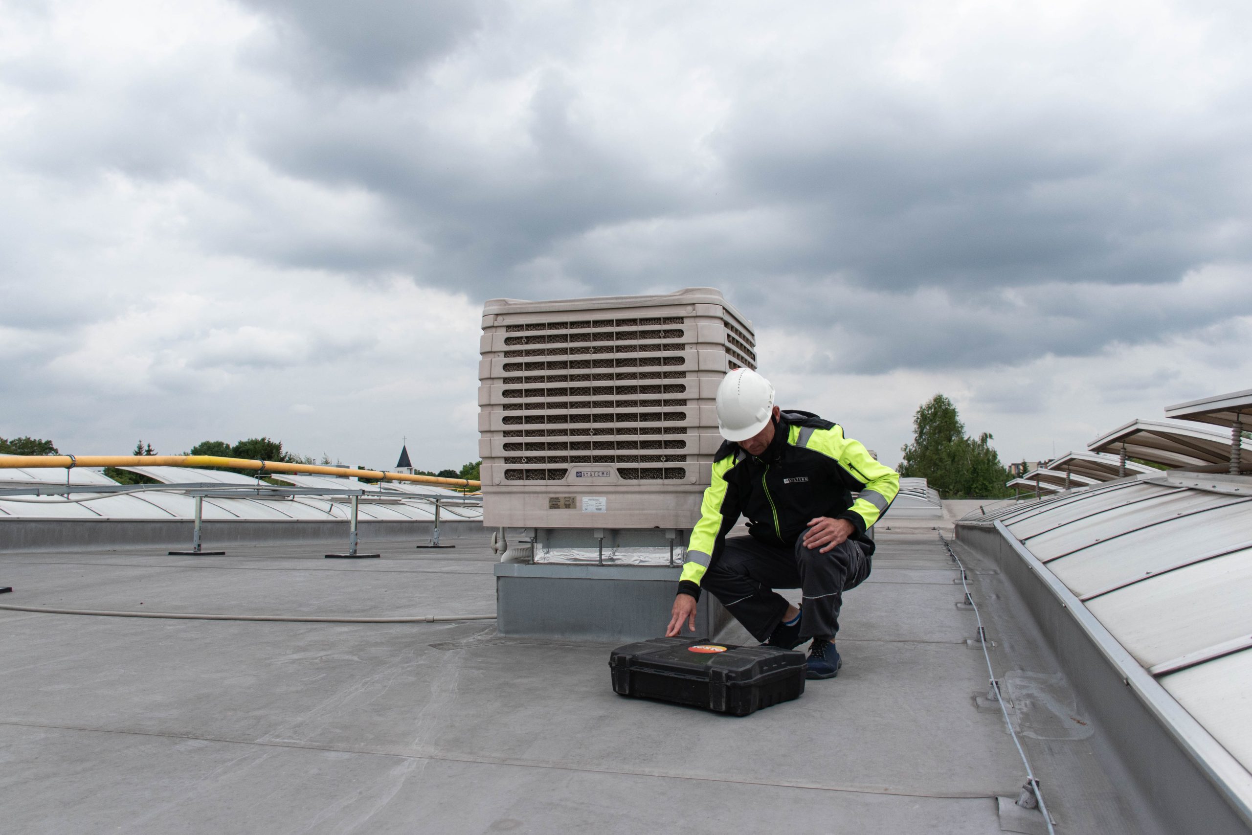 A technician on the roof working on the Fresco system for cooling production halls